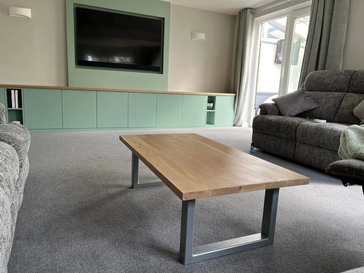 Sage Media Unit and Oak Table Sage green fitted media unit with oak top beneath a wall-mounted TV, with a solid oak coffee table on steel legs